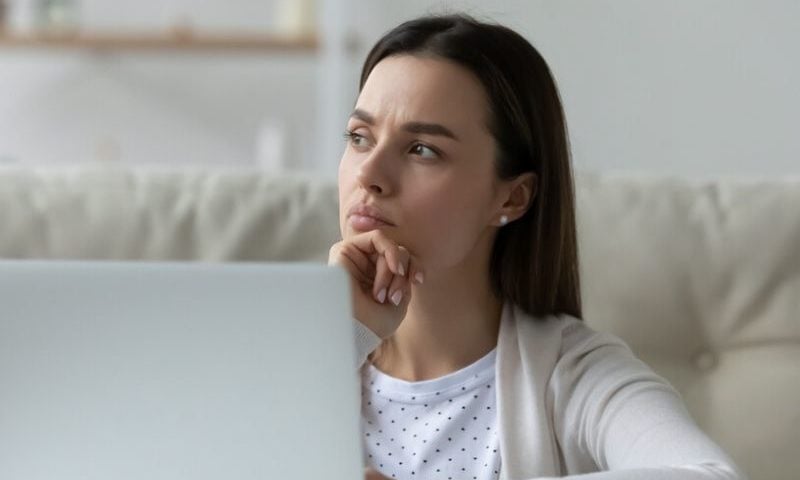 woman with laptop thinking deeply